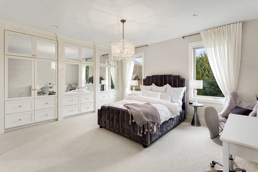 Elegant bedroom with mirrored wardrobe and chandelier.