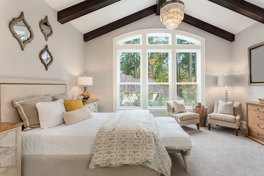 Elegant bedroom with vaulted ceiling and windows.