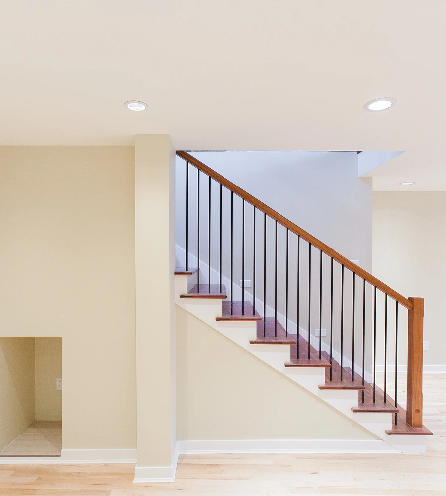Modern staircase with wooden railing and steps.