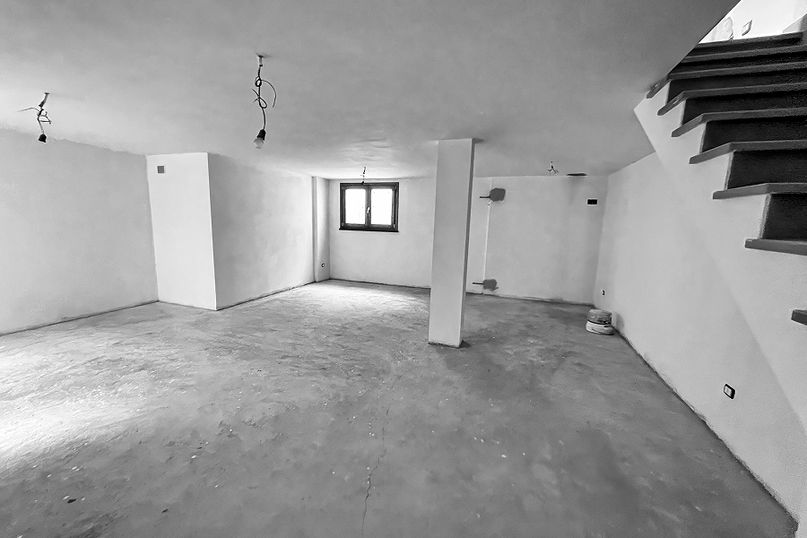 Unfinished basement with bare concrete floor.