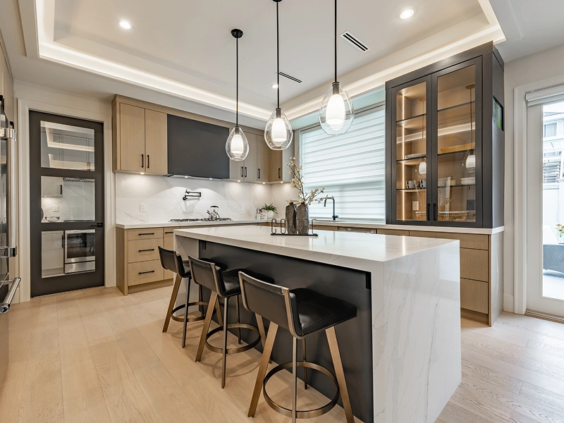 Modern kitchen with island and pendant lights.