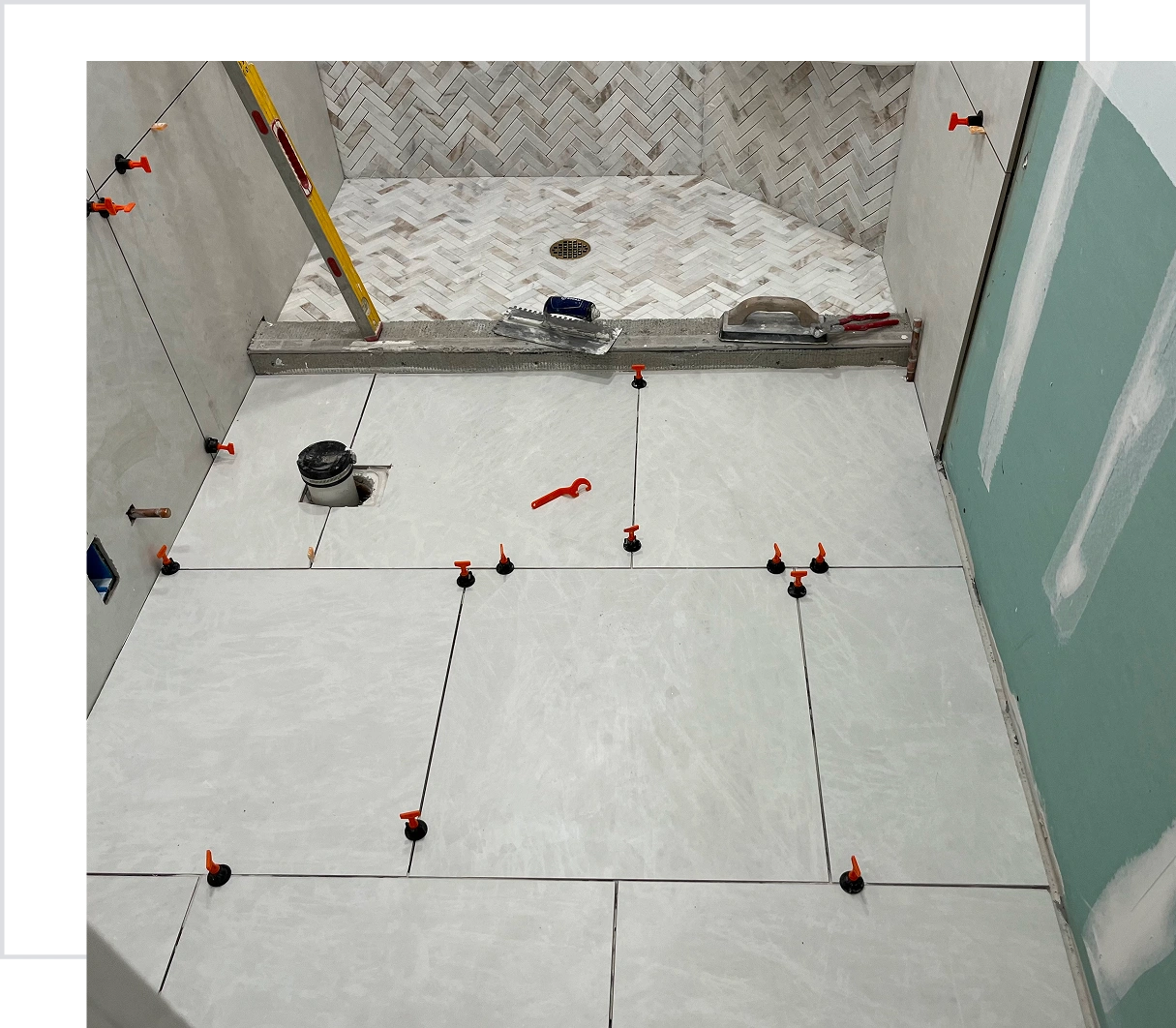 Bathroom tile installation in progress with spacers.