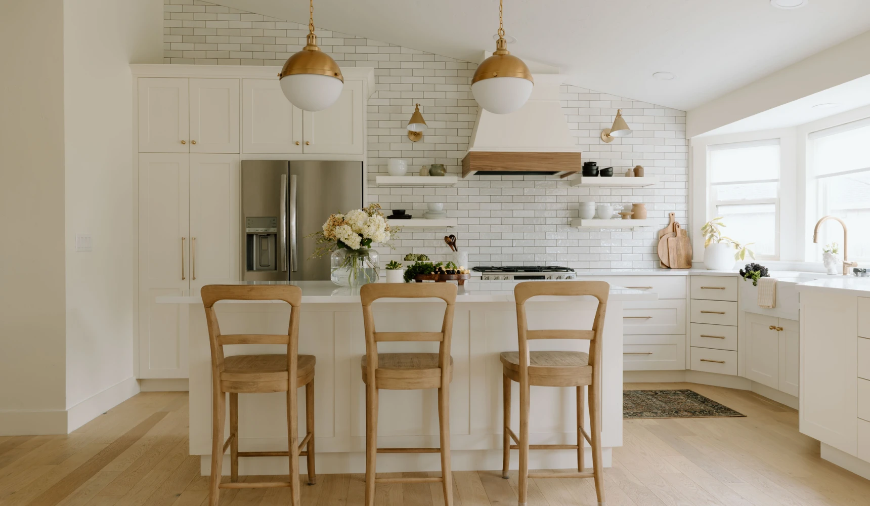 Modern kitchen with island and wooden stools.