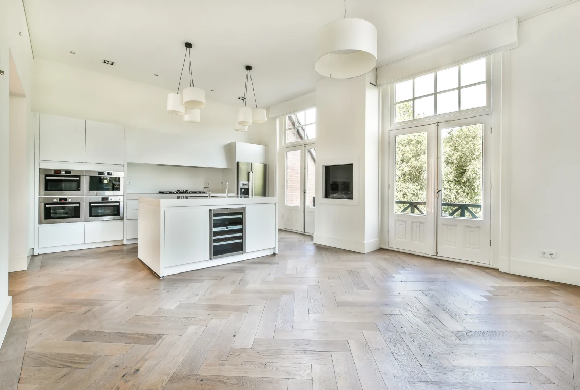 Modern kitchen with wooden herringbone floor.
