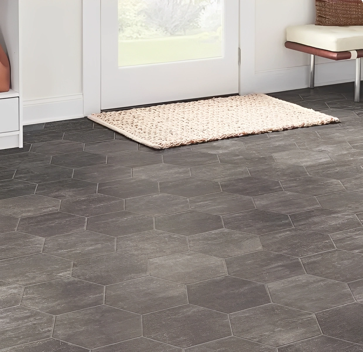 Hexagonal dark floor tiles with light rug.